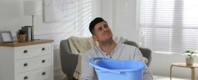 Emotional man collecting water leaking | Roofing Services